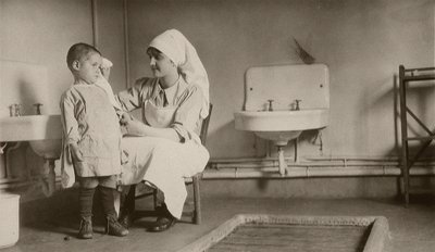Nurse Tending a Sick Child at Passay and Saint-Quentin Colonies for Refugees and Orphans, 1919 by American Photographer